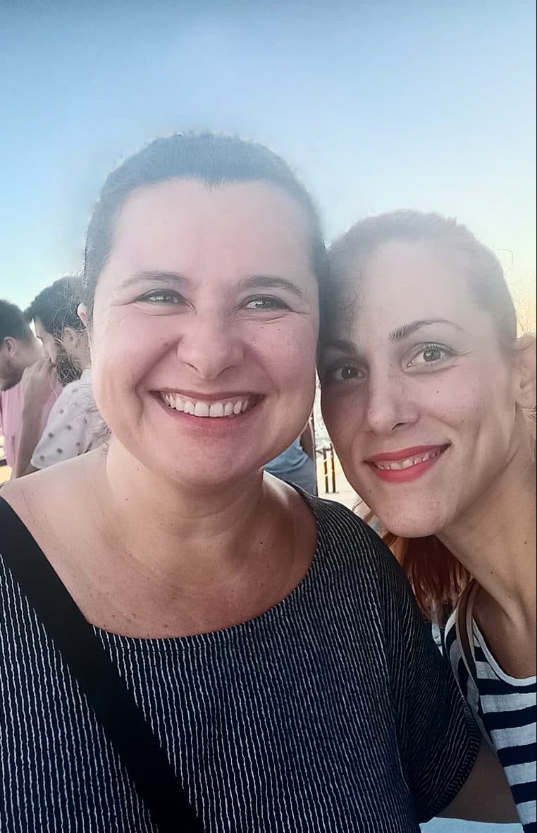 Two smiling ATCOM colleagues together outdoors at sunset