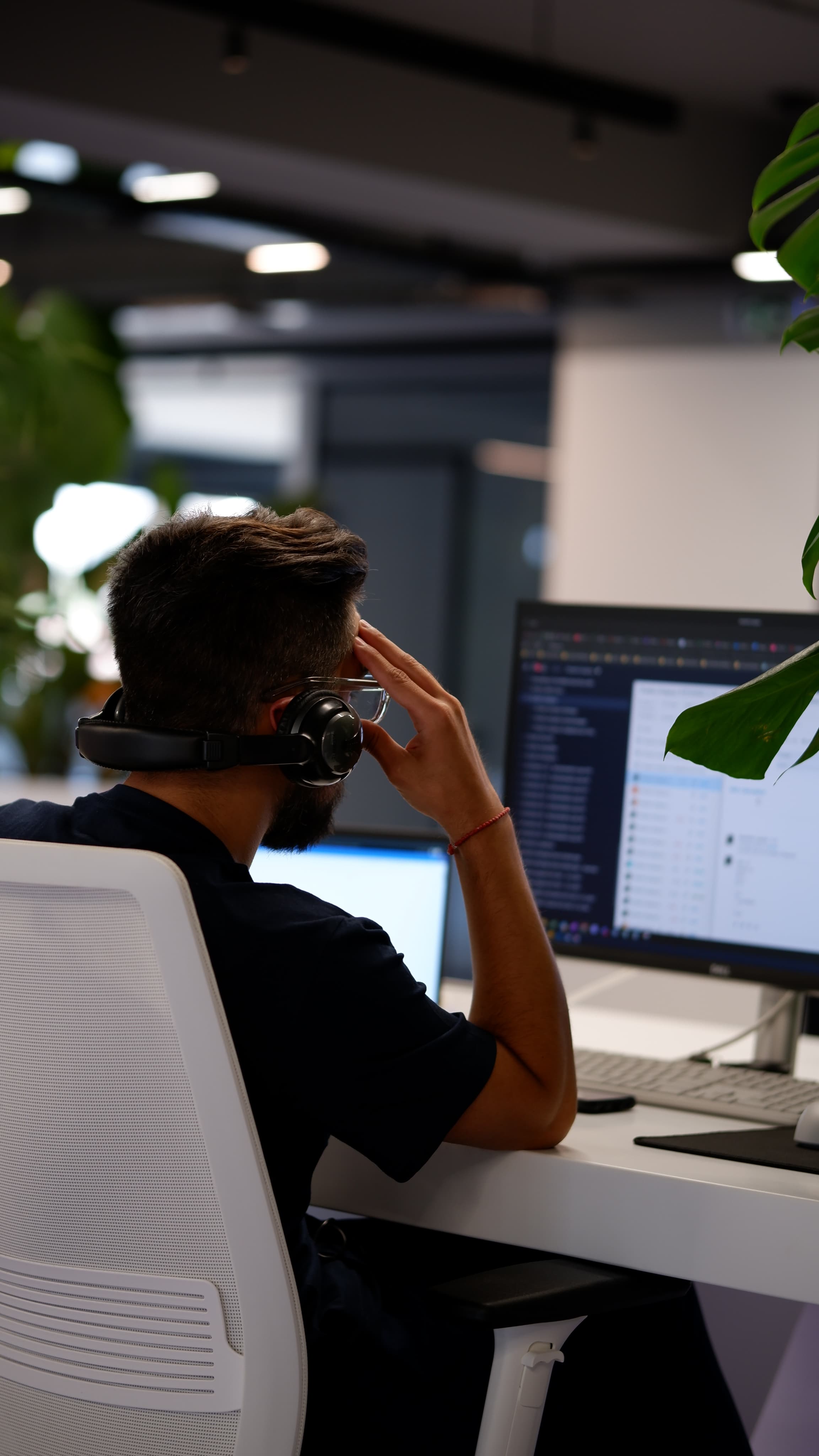 An ATCOM team member with a headset at their desk