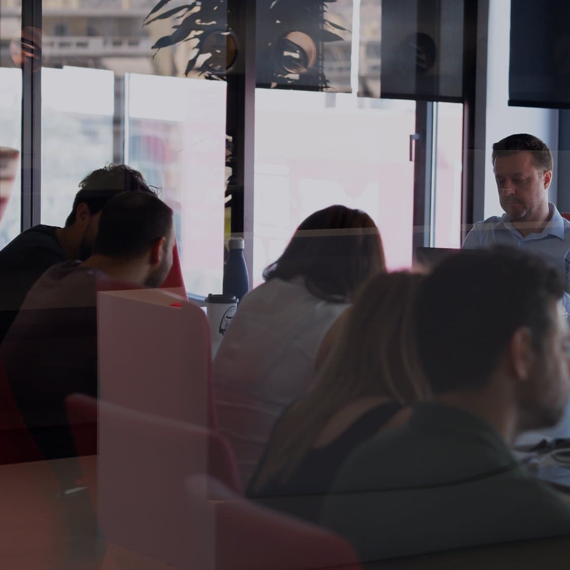 ATCOM team members in a meeting by the window